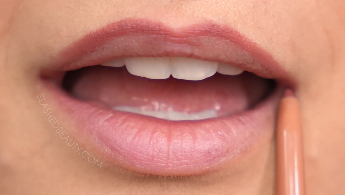how-to-line-lips-bigger-2 | Slashed Beauty Close up of lips with lip liner drawn on the top lip edge. | How to Make Your Lips Look Bigger with Makeup | Slashed Beauty