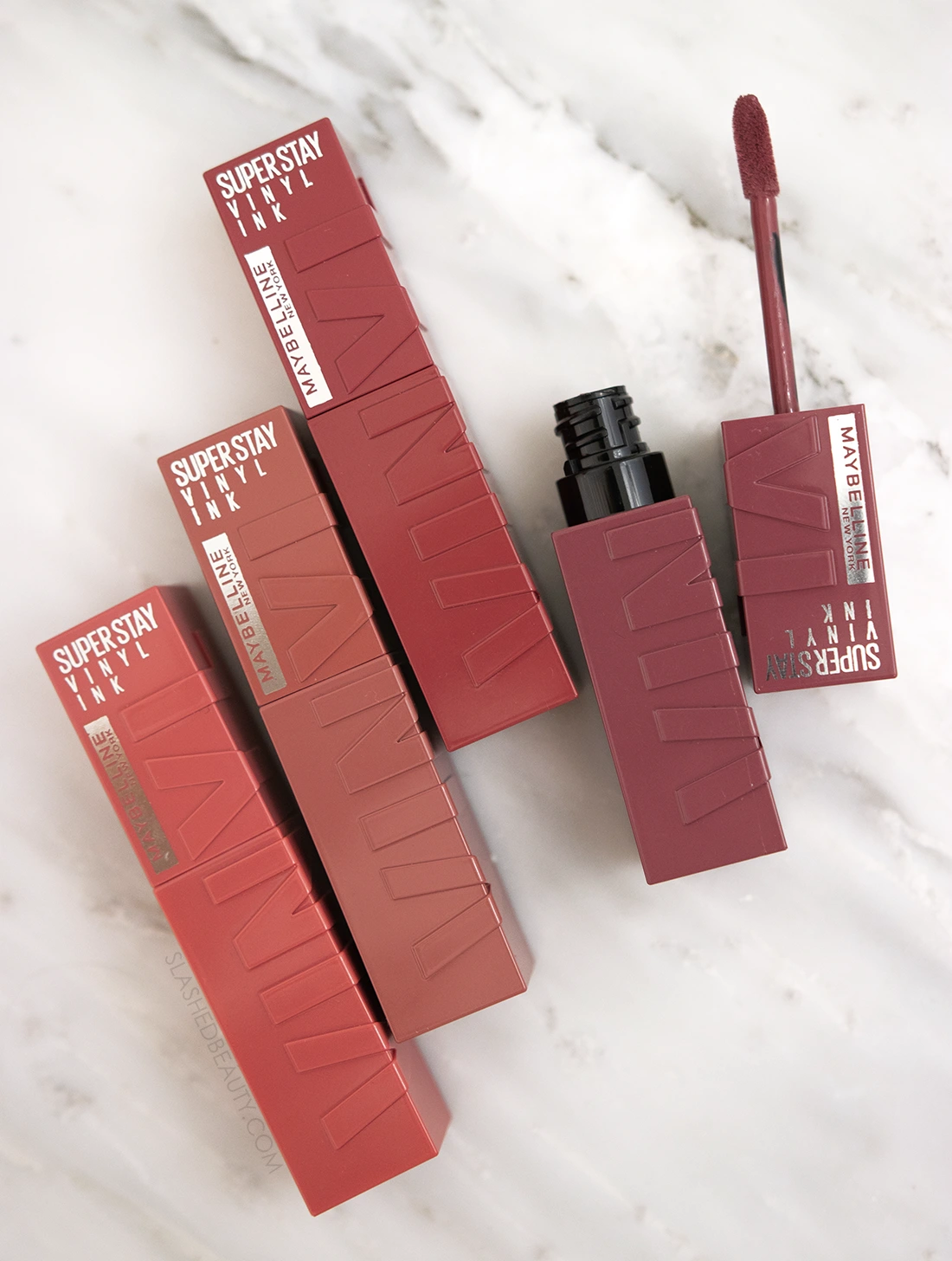 maybelline-super-stay-vinyl-ink-review | Slashed Beauty Tubes of Maybelline Superstay Vinyl Ink Liquid Lipstick lying flat on a marble surface | Maybelline Superstay Vinyl Ink Liquid Lipsticks Review | Slashed Beauty