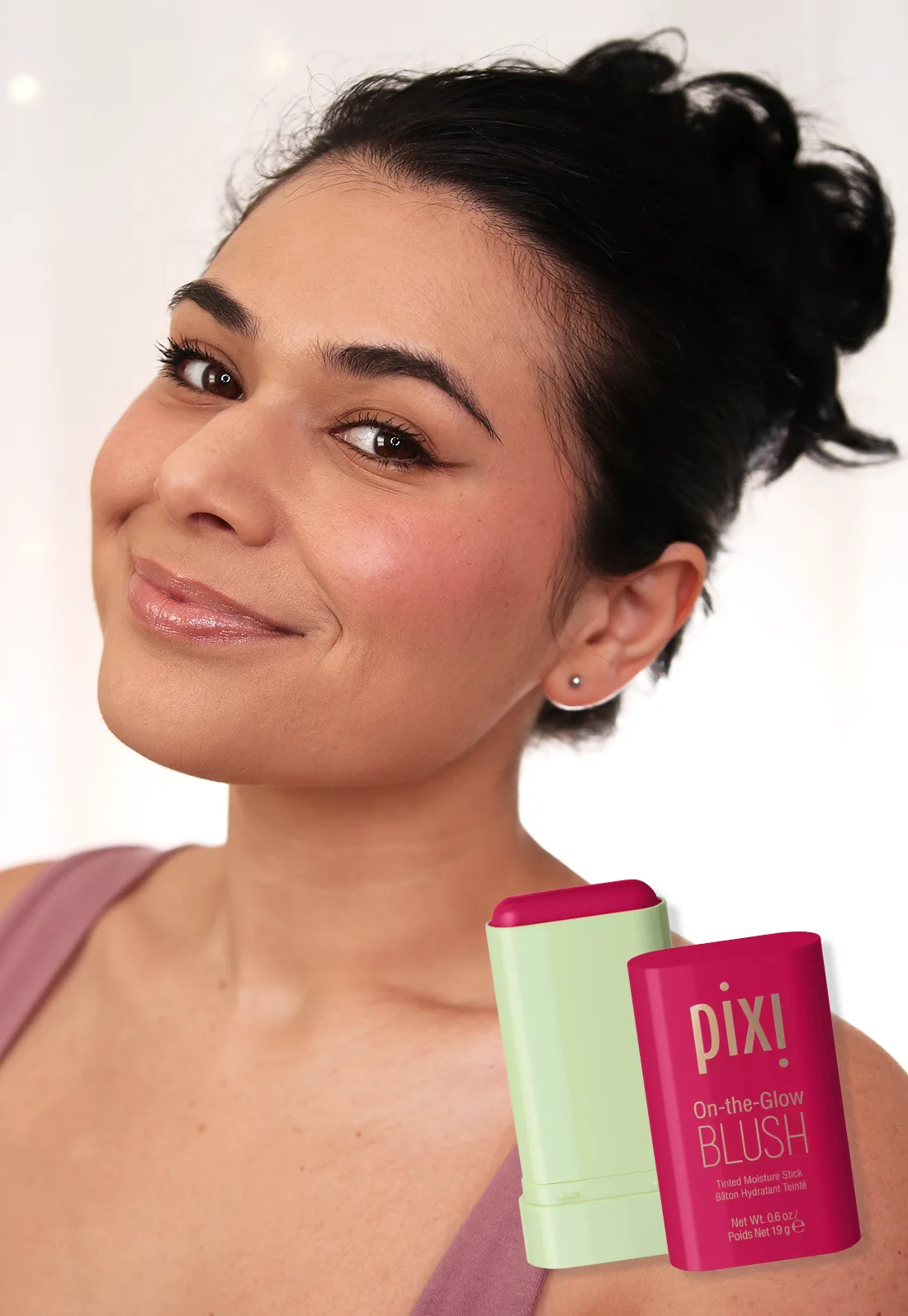 pixi-on-the-glow-blush-ruby-medium-skin | Slashed Beauty Miranda smiling to camera wearing Pixi On-the-Glow Blush Stick in Ruby | Slashed Beauty
