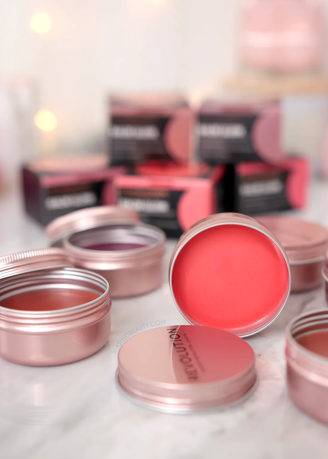 revolution-glow-balm-review | Slashed Beauty Tins of Makeup Revolution Balm Glow lying open on a marble surface | Makeup Revolution Balm Glow Review | Slashed Beauty