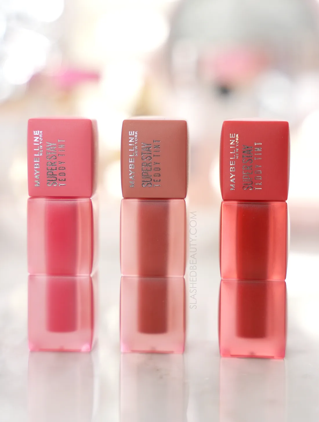 maybelline-teddy-tint-review-wear-test | Slashed Beauty Three tubes of Maybelline Super Sty Teddy Tints standing side by side on a marble surface | Slashed Beauty